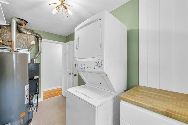 1602 Normandy Dr, Champaign, IL 61821 - laundry room with estacked washer and dryer, water heater, and light tile patterned flooring