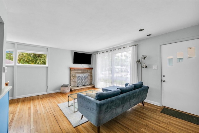 1602 Normandy Dr, Champaign, IL 61821 - living room featuring light wood finished floors, baseboards, and a stone fireplace