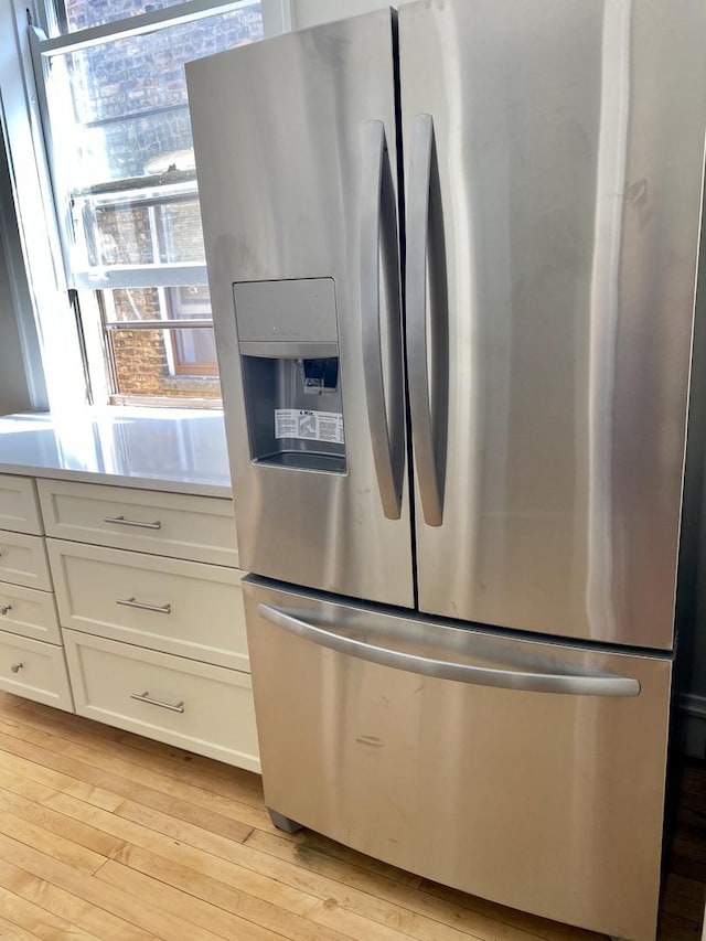 806 Forest Ave Unit 3, Evanston, IL 60202 - detailed view of stainless steel fridge, light wood-type flooring, white cabinetry, and light countertops