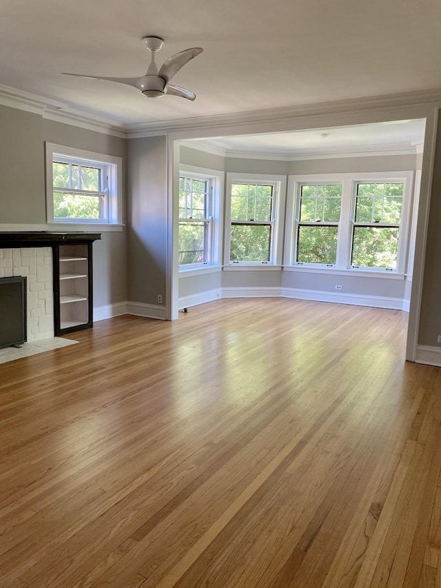 806 Forest Ave Unit 3, Evanston, IL 60202 - unfurnished living room with crown molding, wood finished floors, baseboards, a ceiling fan, and a brick fireplace