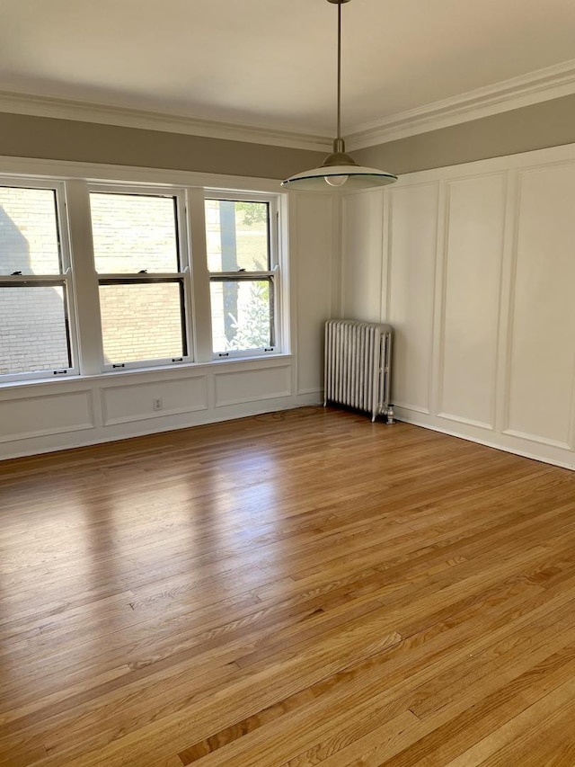 806 Forest Ave Unit 3, Evanston, IL 60202 - spare room with radiator heating unit, a decorative wall, ornamental molding, a ceiling fan, and light wood-style floors