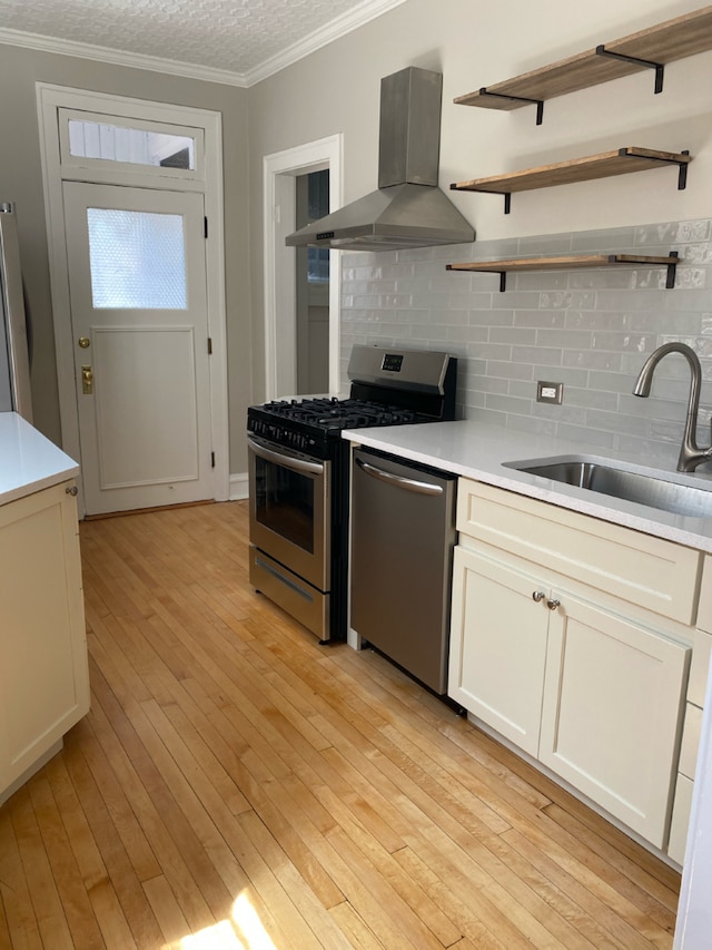806 Forest Ave Unit 3, Evanston, IL 60202 - kitchen featuring wall chimney exhaust hood, appliances with stainless steel finishes, a sink, crown molding, and backsplash