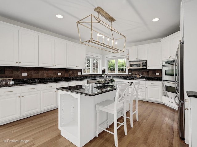 551 W 3rd St, Elmhurst, IL 60126 - kitchen with appliances with stainless steel finishes, white cabinetry, backsplash, light wood-style flooring, and recessed lighting
