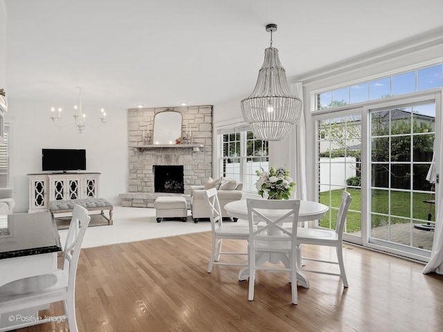 551 W 3rd St, Elmhurst, IL 60126 - dining room with a chandelier, a stone fireplace, and light wood-style flooring