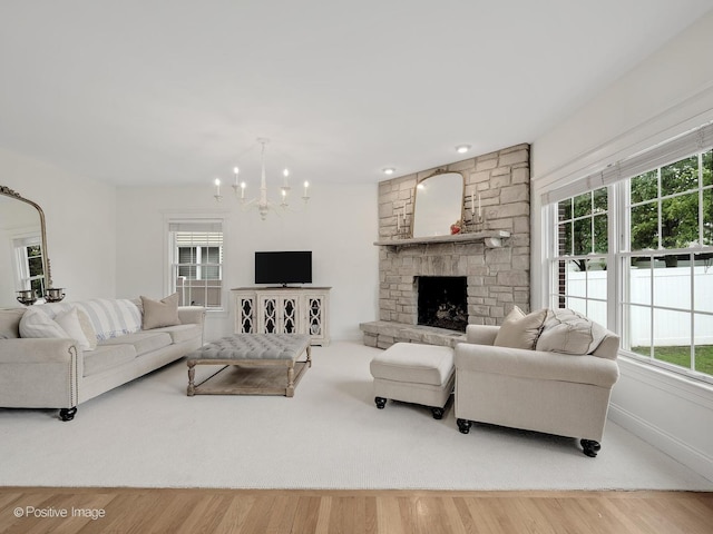 551 W 3rd St, Elmhurst, IL 60126 - living area featuring a chandelier, a stone fireplace, baseboards, and wood finished floors