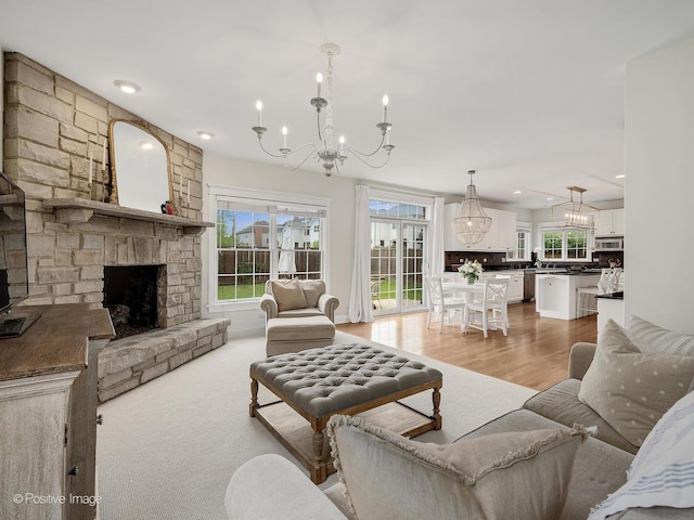 551 W 3rd St, Elmhurst, IL 60126 - living room featuring a chandelier, a stone fireplace, recessed lighting, and light wood finished floors