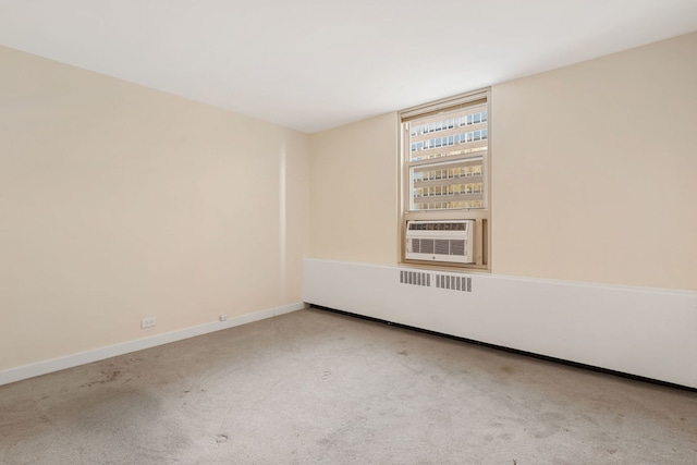 carpeted empty room featuring cooling unit and baseboards
