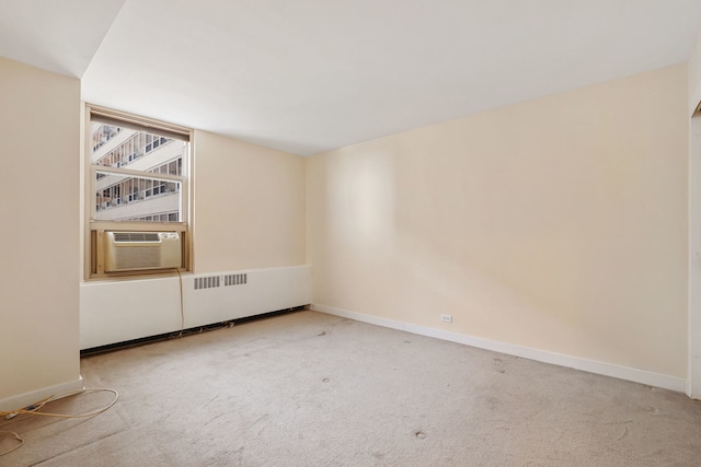 empty room featuring baseboards, carpet flooring, and cooling unit