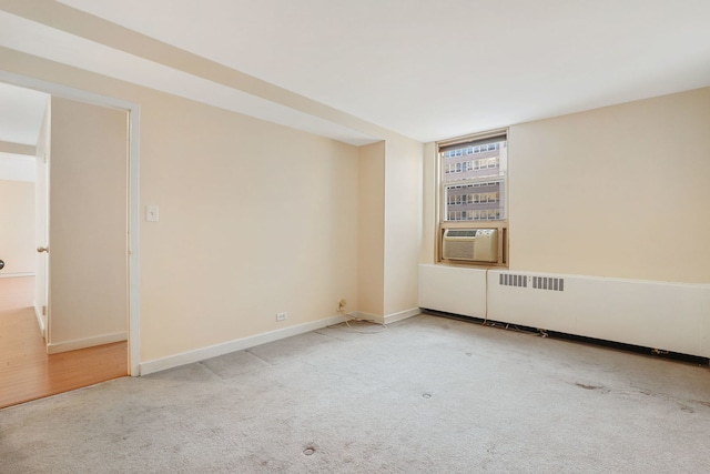 carpeted empty room with cooling unit and baseboards