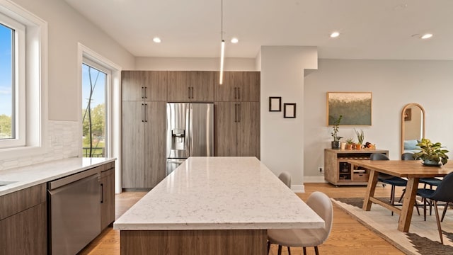 3124 S Benson St Unit 6, Chicago, IL 60608 - kitchen featuring stainless steel appliances, light wood finished floors, decorative backsplash, light stone countertops, and recessed lighting