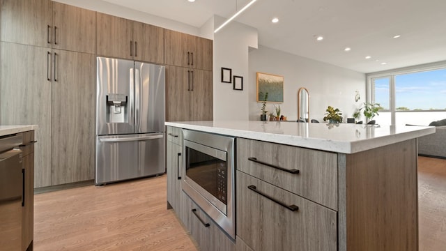 3124 S Benson St Unit 6, Chicago, IL 60608 - kitchen with appliances with stainless steel finishes, light stone counters, a water view, recessed lighting, and light wood-style flooring