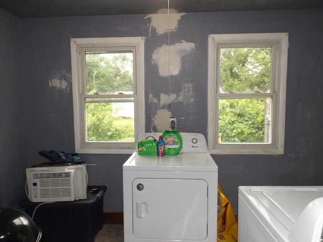 laundry area with washing machine and dryer and a wall mounted air conditioner