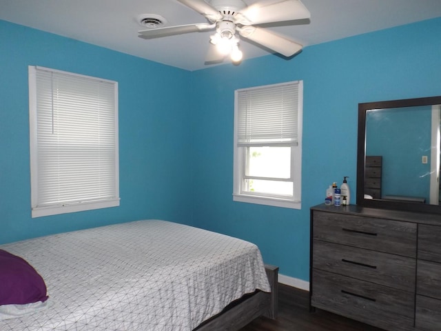 bedroom with wood finished floors, a ceiling fan, and baseboards