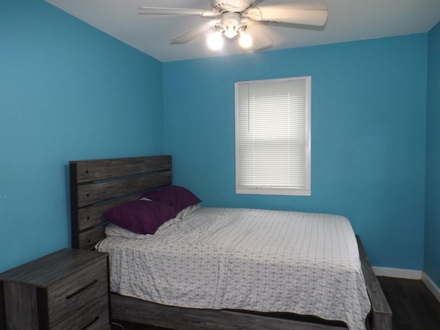 bedroom with a ceiling fan, wood finished floors, and baseboards