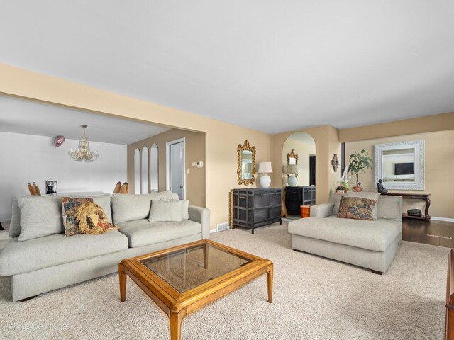 7235 Kiowa Ln, Palos Heights, IL 60463 - living room featuring a chandelier, arched walkways, baseboards, and carpet