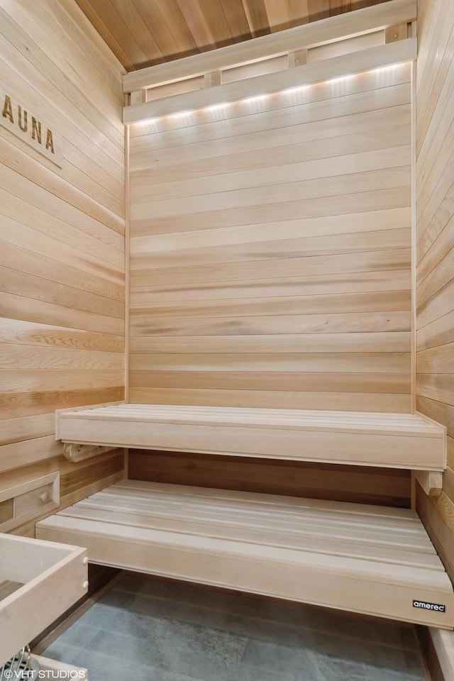 relaxing sauna featuring wooden walls
