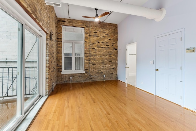 1012 W Diversey Pkwy Unit 2, Chicago, IL 60614 - unfurnished living room featuring brick wall, ceiling fan, and light wood-type flooring