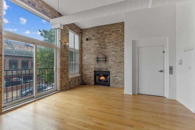1012 W Diversey Pkwy Unit 2, Chicago, IL 60614 - unfurnished living room featuring a towering ceiling, light wood finished floors, and a fireplace