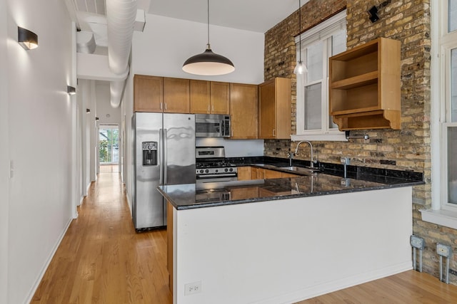 1012 W Diversey Pkwy Unit 2, Chicago, IL 60614 - kitchen with appliances with stainless steel finishes, a sink, light wood-type flooring, brown cabinetry, and dark stone countertops