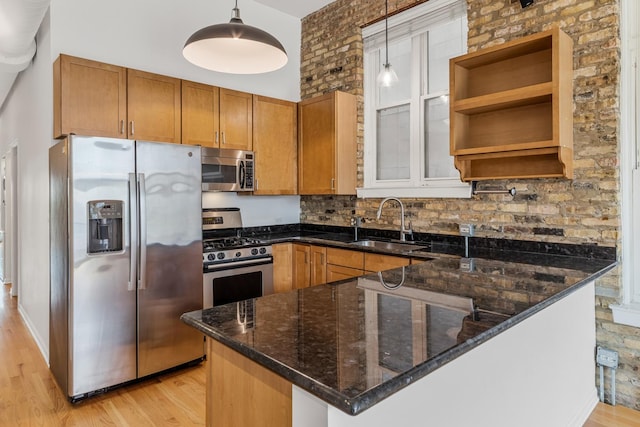 1012 W Diversey Pkwy Unit 2, Chicago, IL 60614 - kitchen featuring stainless steel appliances, a sink, light wood-style floors, a peninsula, and dark stone counters