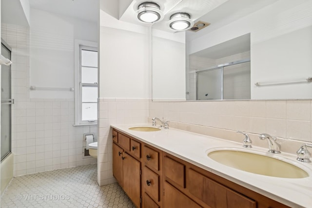 827 Forest Ave, River Forest, IL 60305 - bathroom featuring tile walls, double vanity, tile patterned floors, and a wainscoted wall