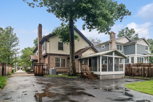827 Forest Ave, River Forest, IL 60305 - rear view of property with a sunroom, a chimney, brick siding, and asphalt driveway