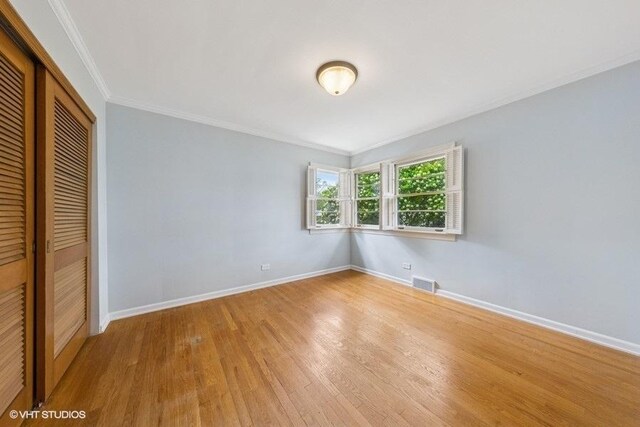10 N Waverly Pl, Mount Prospect, IL 60056 - unfurnished bedroom with a closet, baseboards, light wood-type flooring, and crown molding