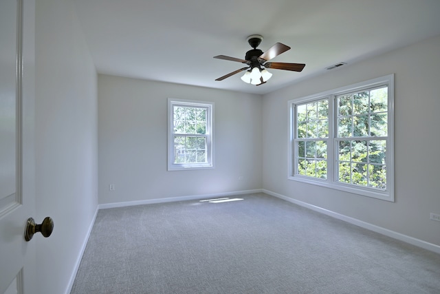 carpeted empty room with plenty of natural light, baseboards, and a ceiling fan