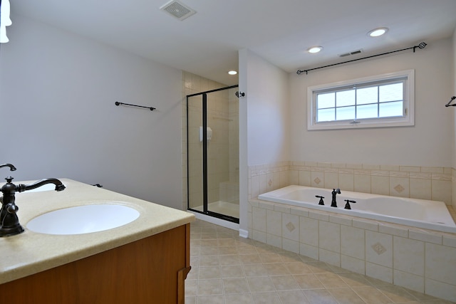 bathroom with a garden tub, a shower stall, double vanity, tile patterned flooring, and recessed lighting