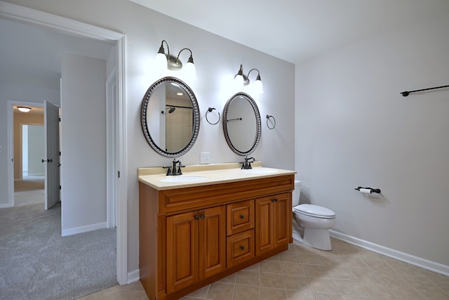 bathroom featuring double vanity, toilet, tile patterned floors, and baseboards
