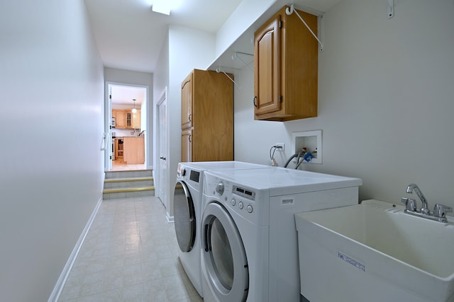 laundry area featuring cabinet space, baseboards, washing machine and dryer, and light tile patterned floors