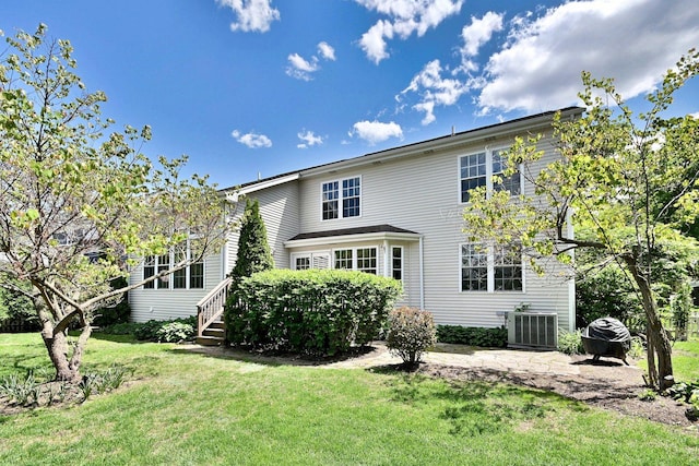 back of house with central AC and a lawn