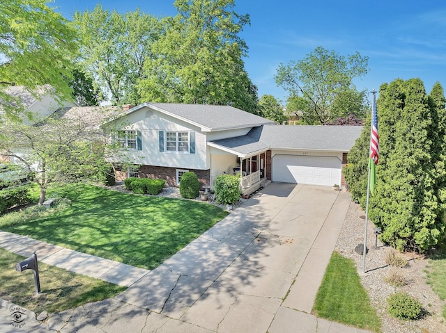 623 Woodstock Ln, Bourbonnais, IL 60914 - tri-level home with brick siding, an attached garage, driveway, a front lawn, and roof with shingles