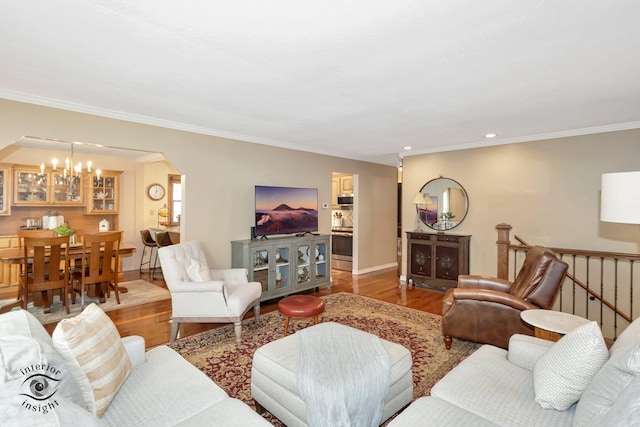 623 Woodstock Ln, Bourbonnais, IL 60914 - living area featuring wood finished floors, a chandelier, ornamental molding, baseboards, and arched walkways