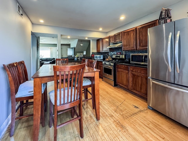 1703 S Ruble St, Chicago, IL 60616 - kitchen featuring stainless steel appliances, dark countertops, light wood-style floors, under cabinet range hood, and recessed lighting