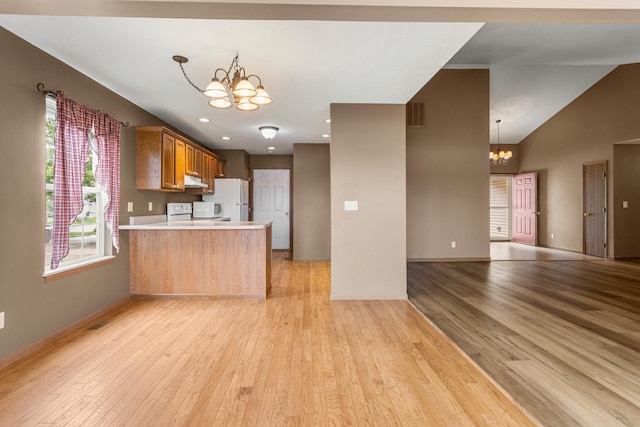 610 Chestnut Dr, Saint Joseph, IL 61873 - kitchen featuring a chandelier, white appliances, open floor plan, a peninsula, and light countertops