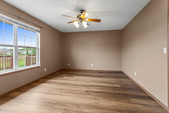 610 Chestnut Dr, Saint Joseph, IL 61873 - spare room featuring a ceiling fan, light wood-style flooring, and baseboards