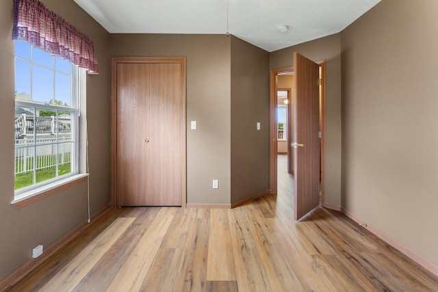 610 Chestnut Dr, Saint Joseph, IL 61873 - unfurnished bedroom featuring light wood-type flooring, a closet, and baseboards