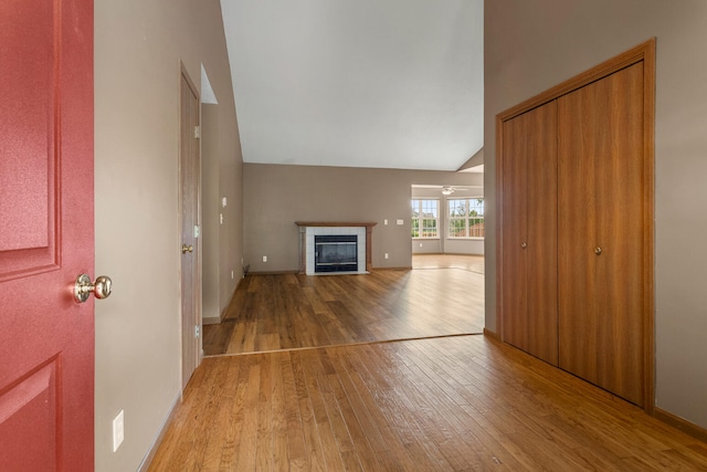 610 Chestnut Dr, Saint Joseph, IL 61873 - unfurnished living room featuring light wood-style floors, a fireplace, high vaulted ceiling, and baseboards