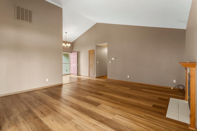 610 Chestnut Dr, Saint Joseph, IL 61873 - unfurnished living room featuring high vaulted ceiling, a chandelier, and light wood-type flooring