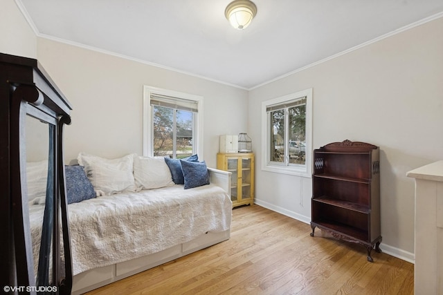 bedroom featuring wood finished floors, multiple windows, crown molding, and baseboards