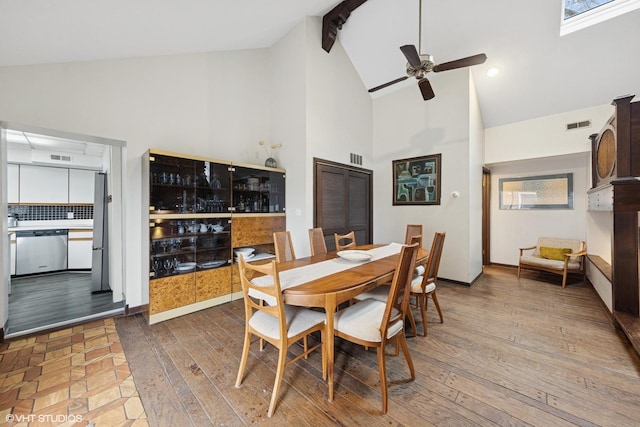 dining area featuring high vaulted ceiling, beam ceiling, ceiling fan, and hardwood / wood-style flooring