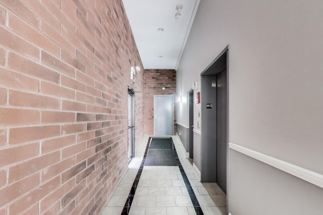 4440 N Kedzie Ave Unit 401, Chicago, IL 60625 - corridor featuring inlaid floor details, elevator, brick wall, baseboards, and ornamental molding