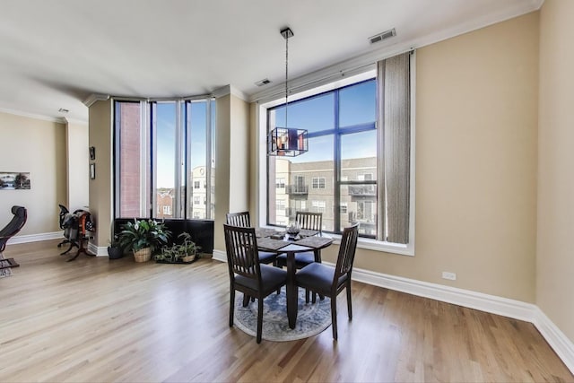 4440 N Kedzie Ave Unit 401, Chicago, IL 60625 - dining space featuring ornamental molding, wood finished floors, a chandelier, and baseboards