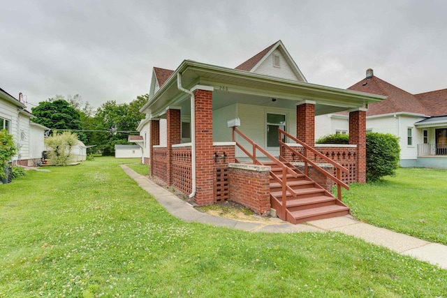 206 N Pine St, Villa Grove, IL 61956 - view of front of house featuring a front lawn, brick siding, covered porch, and stairway