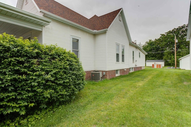 206 N Pine St, Villa Grove, IL 61956 - view of property exterior featuring central air condition unit, a yard, and roof with shingles