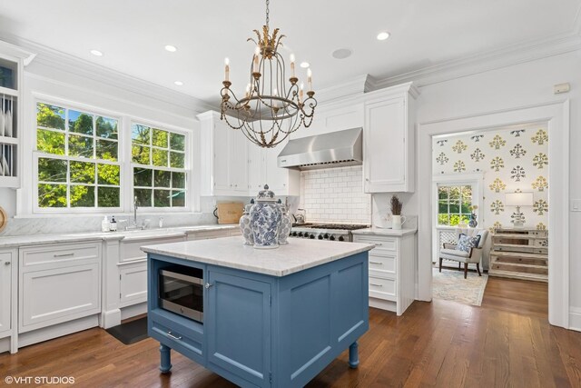 550 Rosemary Rd, Lake Forest, IL 60045 - kitchen featuring wall chimney range hood, appliances with stainless steel finishes, blue cabinets, white cabinets, and a chandelier