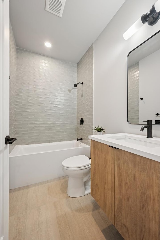 944 Beloit Ave Unit 2, Forest Park, IL 60130 - full bathroom featuring washtub / shower combination, toilet, vanity, wood finished floors, and recessed lighting