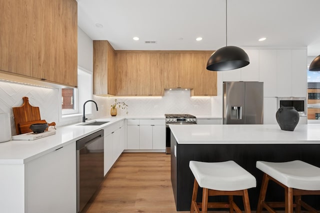 944 Beloit Ave Unit 2, Forest Park, IL 60130 - kitchen with appliances with stainless steel finishes, modern cabinets, a sink, a breakfast bar, and light countertops