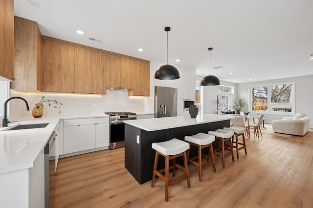 944 Beloit Ave Unit 2, Forest Park, IL 60130 - kitchen with appliances with stainless steel finishes, modern cabinets, a sink, a breakfast bar, and light countertops